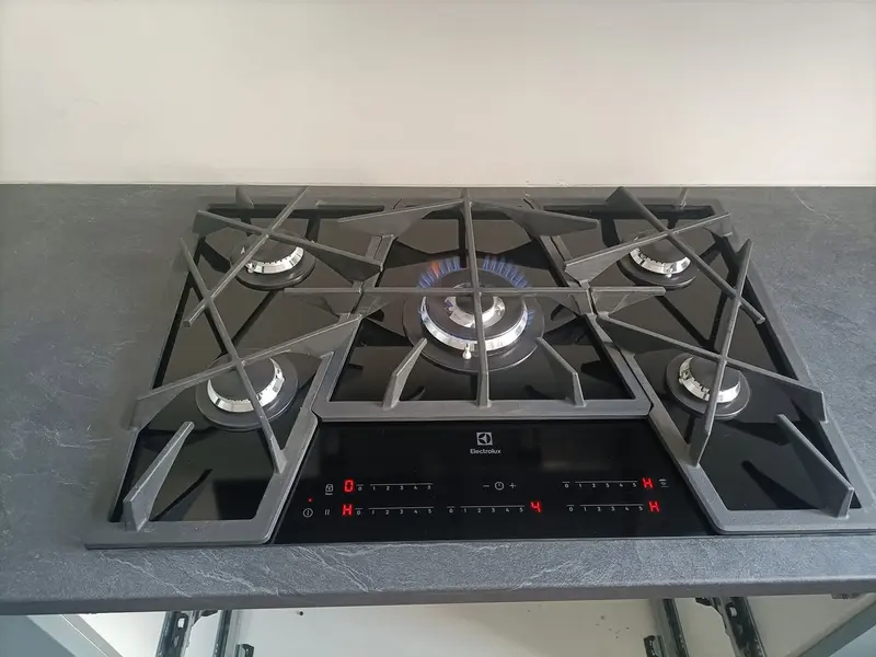 Pięciopalnikowa płyta gazowa Electrolux w ciemnym blacie, środkowy palnik zapalony