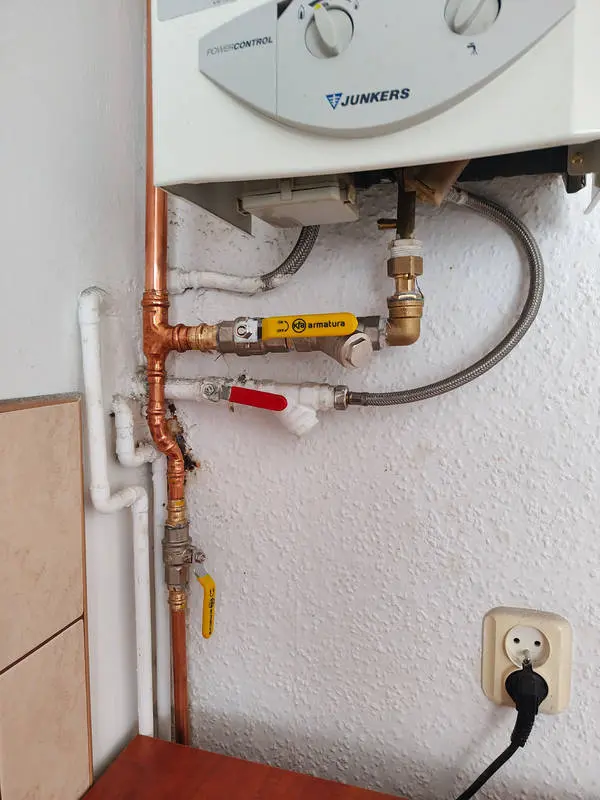 Piecyk gazowy Junkers podłączony do miedzianej instalacji gazowej z żółtym zaworem kulowym