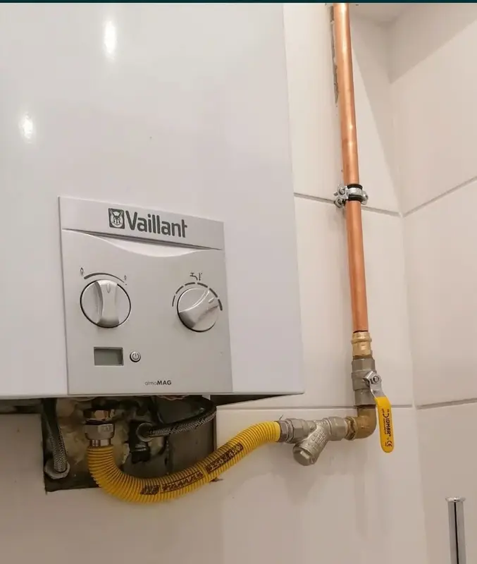 Piecyk gazowy Vaillant podłączony żółtym wężem gazowym do miedzianej instalacji z zaworem