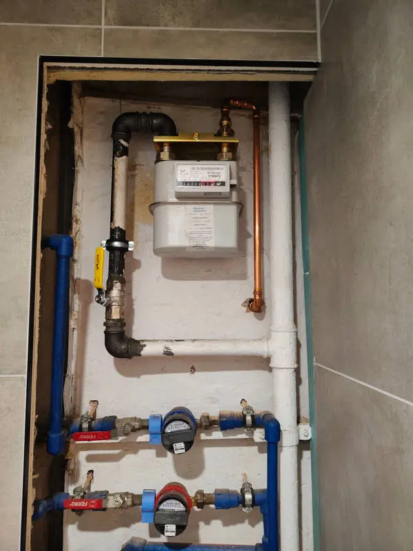 Gazomierz w szafce instalacyjnej podłączony do instalacji z miedzi i stali